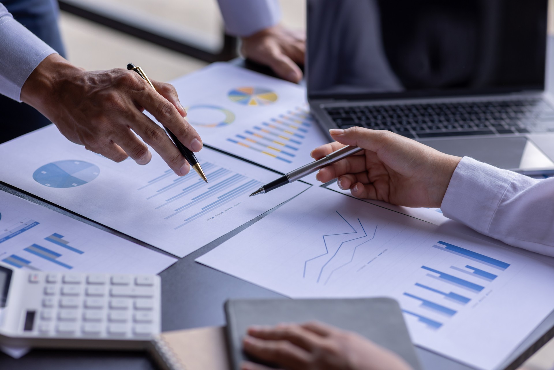 Les gens d’affaires de l’équipe ou une équipe de comptables analysent des tableaux de données, des graphiques et un tableau de bord sur un écran d’ordinateur portable afin de préparer un rapport statistique et de discuter des données financièr