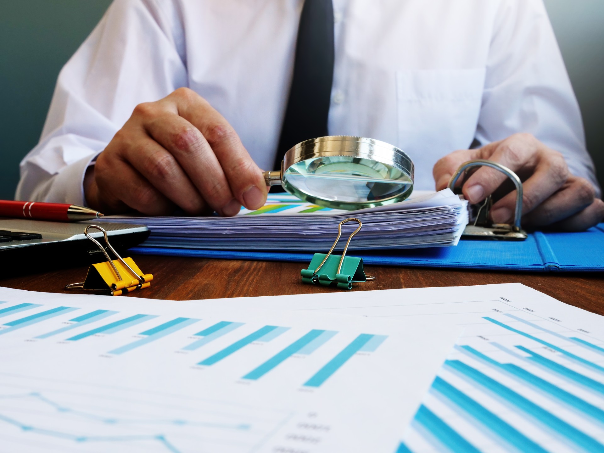 Le vérificateur effectue une vérification interne de l’entreprise et vérifie le rapport financier avec la loupe.